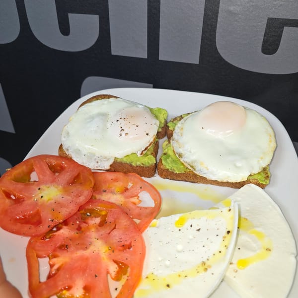 Avocado toast with eggs, tomato and fresh cheese.